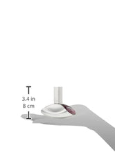 Curved perfume bottle resting on an open palm, silver glass with purple rim