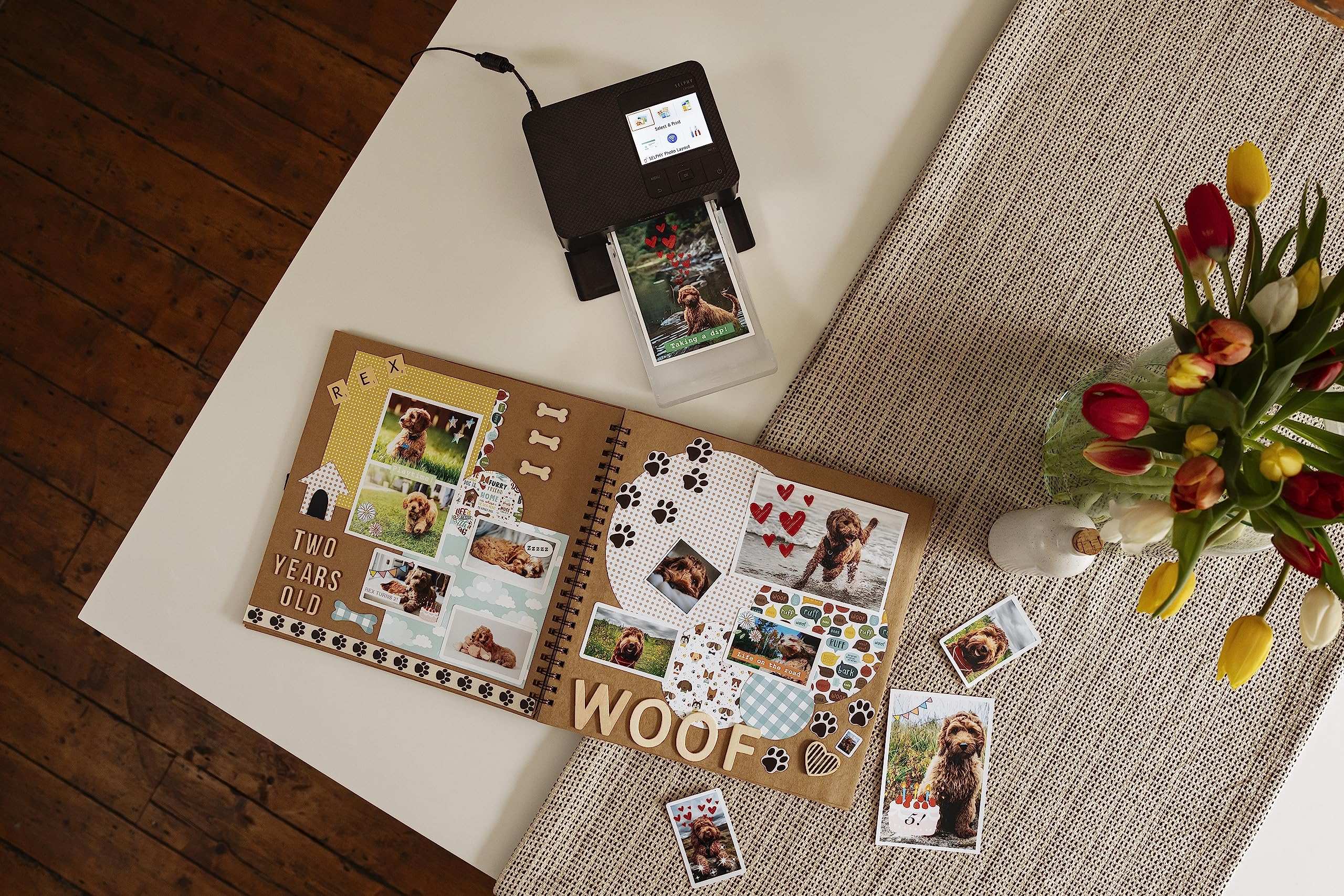 Canon RP108 ink and paper set printing pet photos for a scrapbook on a white and beige table
