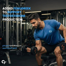 Man lifting dumbbells in a gym while wearing a blue athletic t-shirt