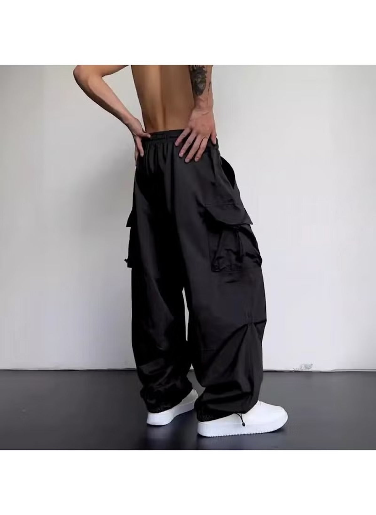 Black cargo style wide leg pants for ladies with multiple pockets worn with white sneakers