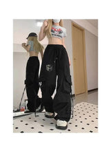 Black wide-leg cargo pants with drawstring waist and layered pocket details