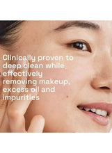 Facial cleanser application on woman's cheek with fingers