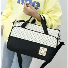 Travel diaper bag with dotted cream top, black bottom, front pocket and teddy patch