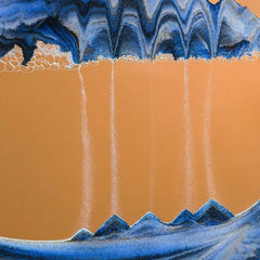 Huitich moving sand art picture with blue sand creating flowing mountain shapes on tan background