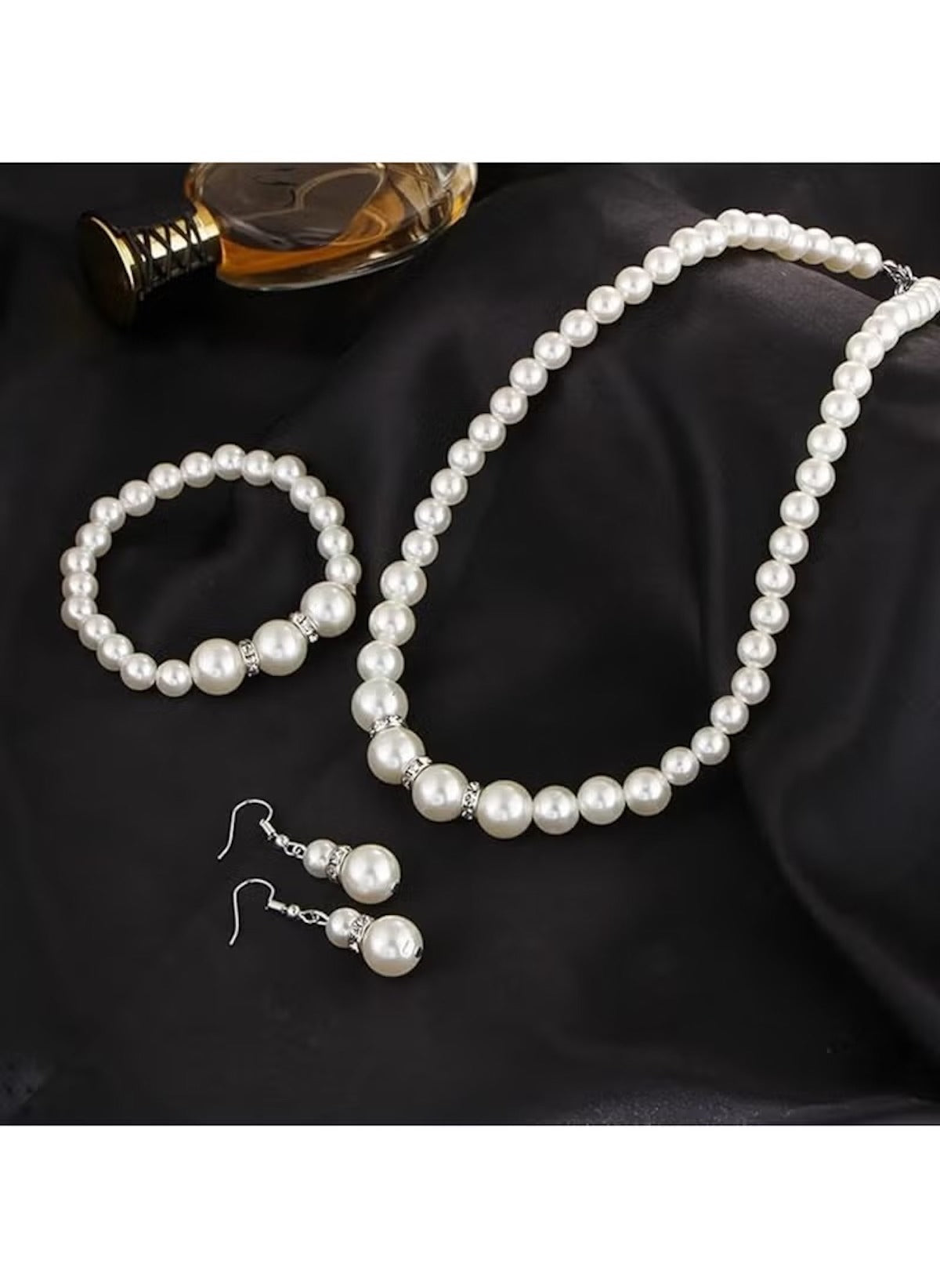 Huitich imitation pearl jewelry set including necklace bracelet and earrings on black fabric