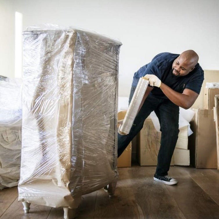 Man wrapping furniture using clear pallet wrapping roll 50cm for secure packaging and protection