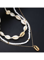 Huitich 14 piece layered beach jewelry featuring white beads and gold shell charms on black background