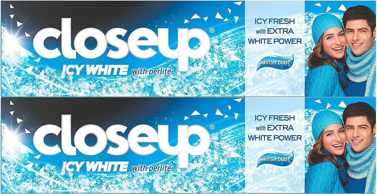 Closeup Icy White Toothpaste Winterblast pack icy blue double pack with smiling couple in winter hats and snowflakes