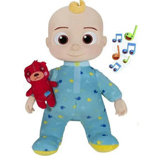 Stuffed baby doll in light blue patterned jumpsuit with yellow accents, holding red plush