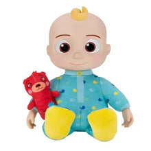 Stuffed baby doll in light blue patterned outfit with yellow feet, holding red mini plush