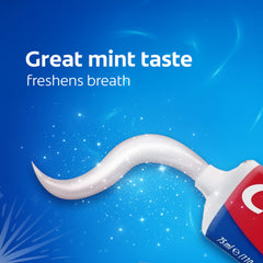 Colgate cavity protection toothpaste mint paste swirl from red and blue Colgate tube on blue background
