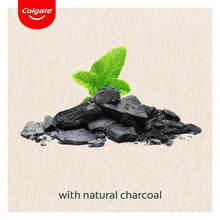 Toothpaste ingredient graphic with charcoal chunks and green mint leaves.