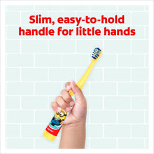 Kids Minions toothbrush held in hand, extra-soft bristles on yellow handle