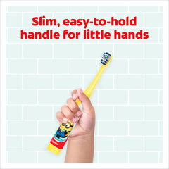 Child hand holding Colgate kids Minions toothbrush with slim yellow handle and blue bristles