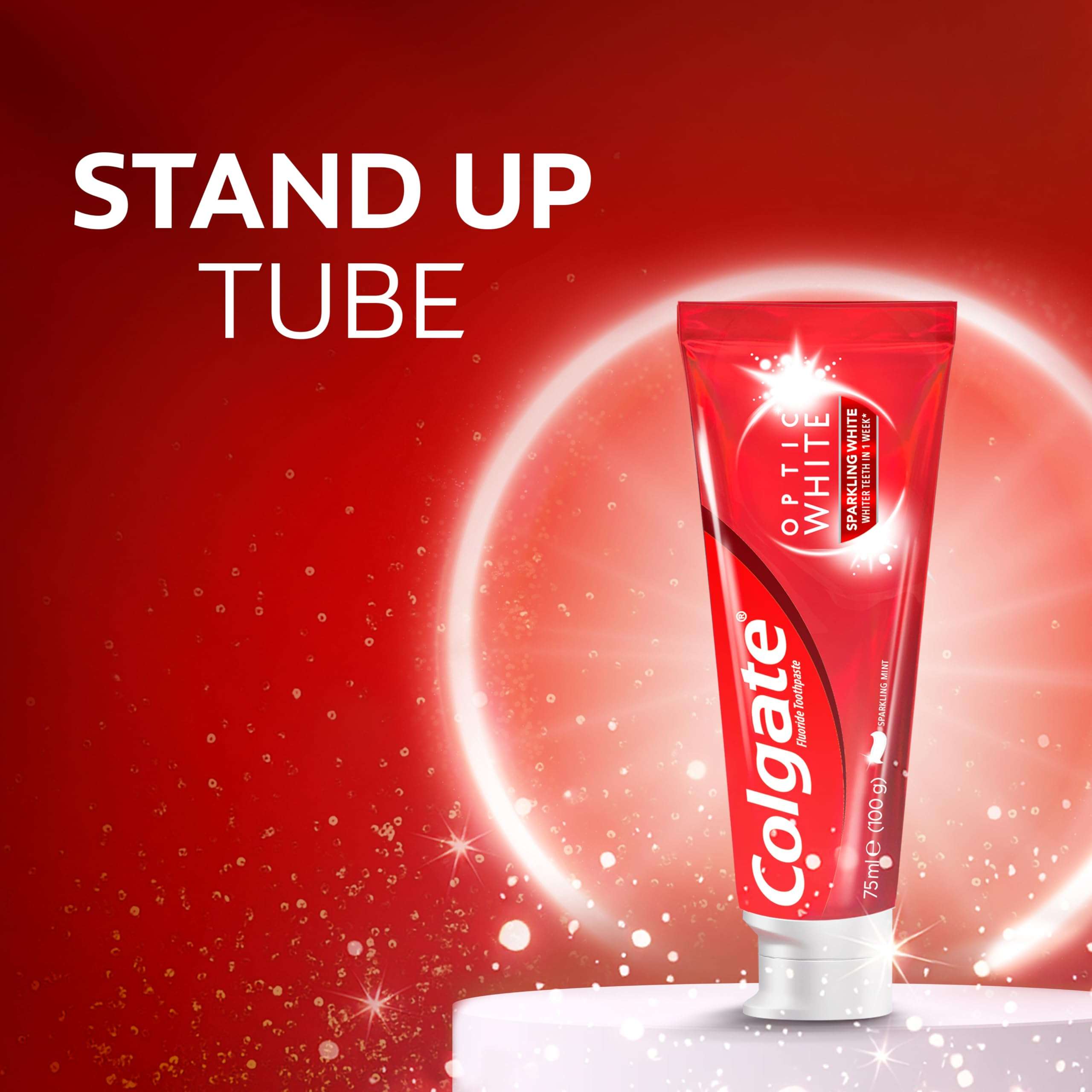 Colgate Optic White toothpaste standing red tube with white cap on pedestal against sparkling red background