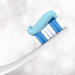 Close up toothbrush with blue and white bristles topped with speckled gel of Colgate Optic Whitening toothpaste.