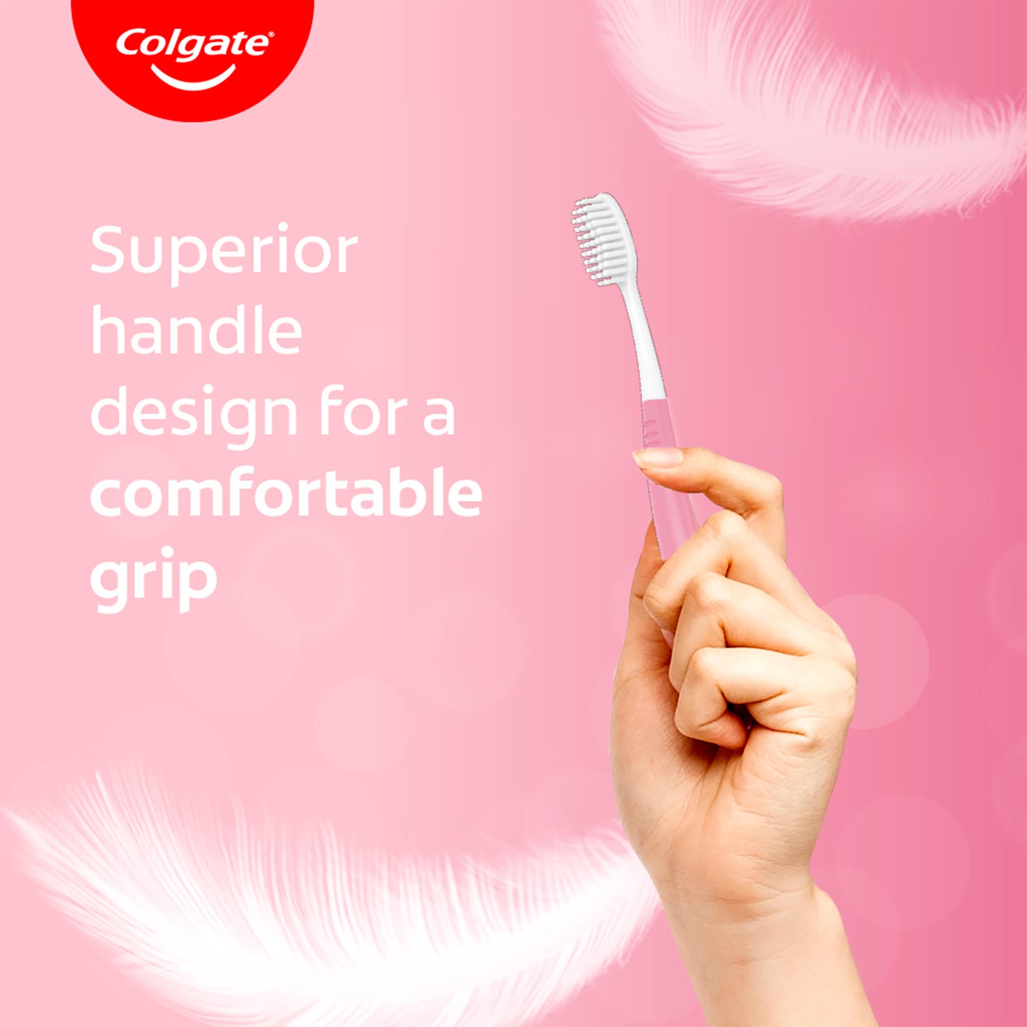Hand holds pink Colgate sensitive toothbrush pack showing soft bristles and superior handle for comfortable grip