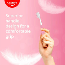 Colgate toothbrush with comfortable grip handle, white bristles held in hand