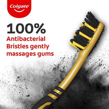 Medium charcoal toothbrush with yellow handle and black bristle head close-up
