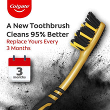 Medium charcoal toothbrush with yellow handle and black bristles, angled view