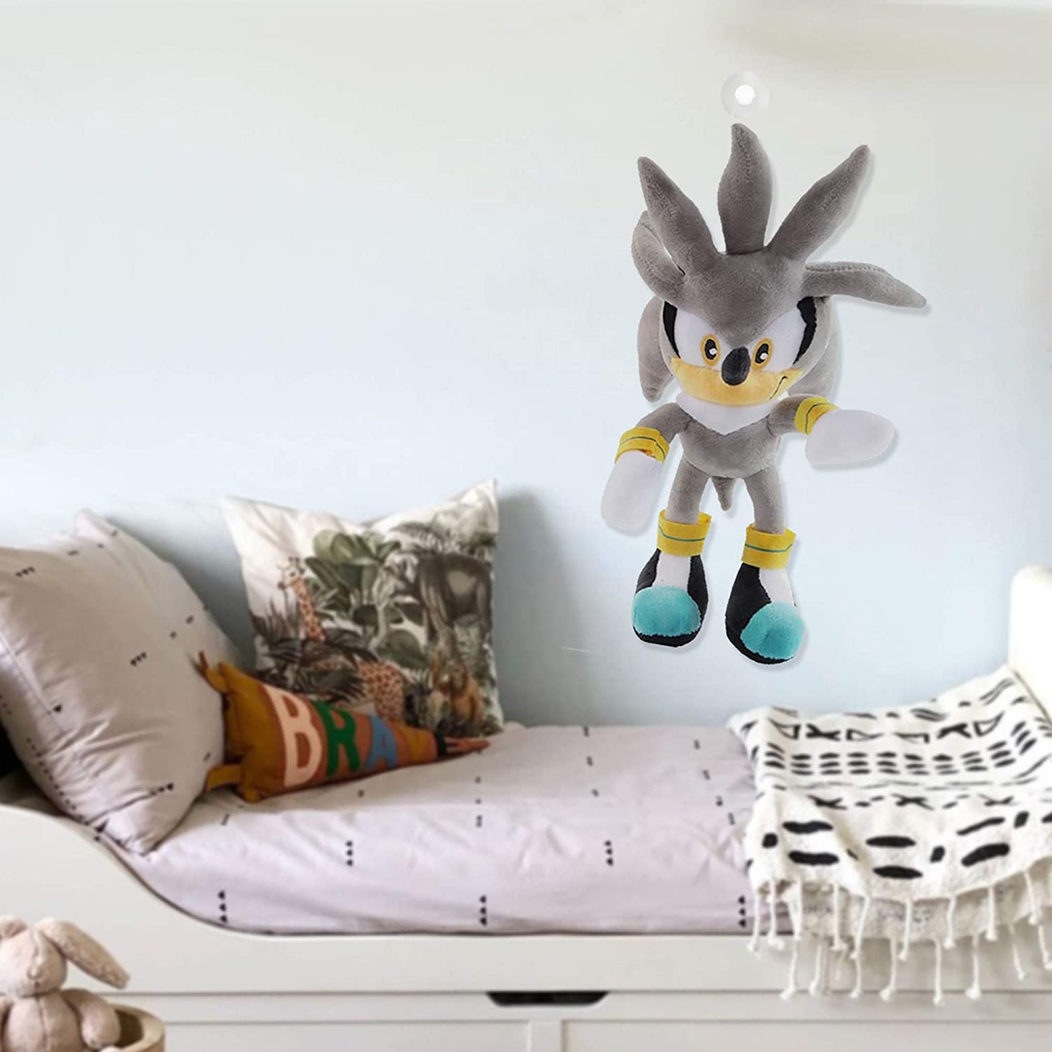 Huitich collectible sonic plush toy hanging above a cozy bed with decorative pillows