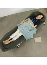 Dark green folding sleeping cot with attached pillow and padded mattress