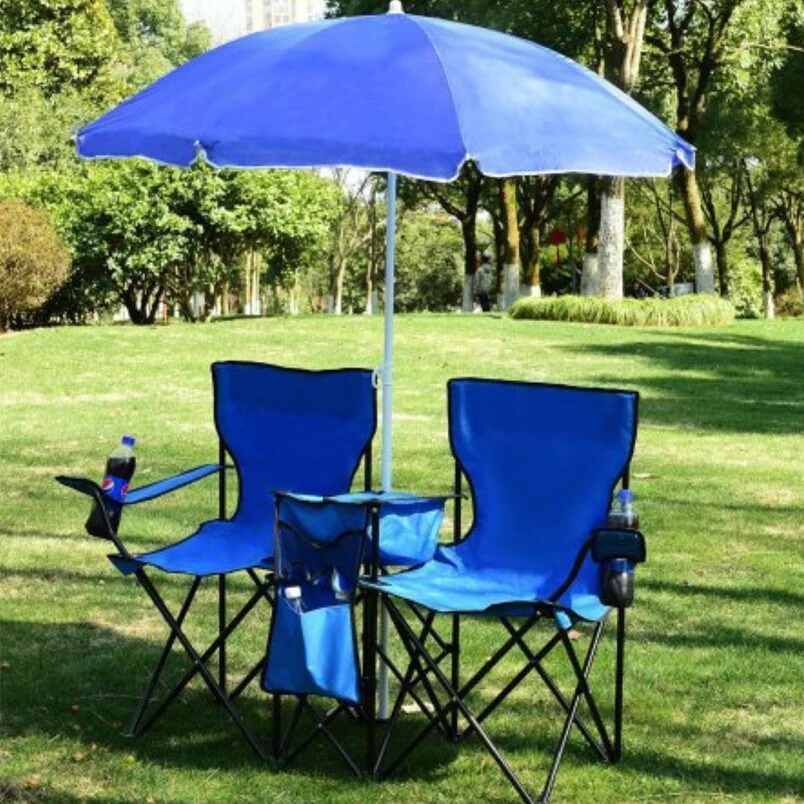 Huitich compact travel camping chair set with blue fabric, cup holders, and a large umbrella in a park