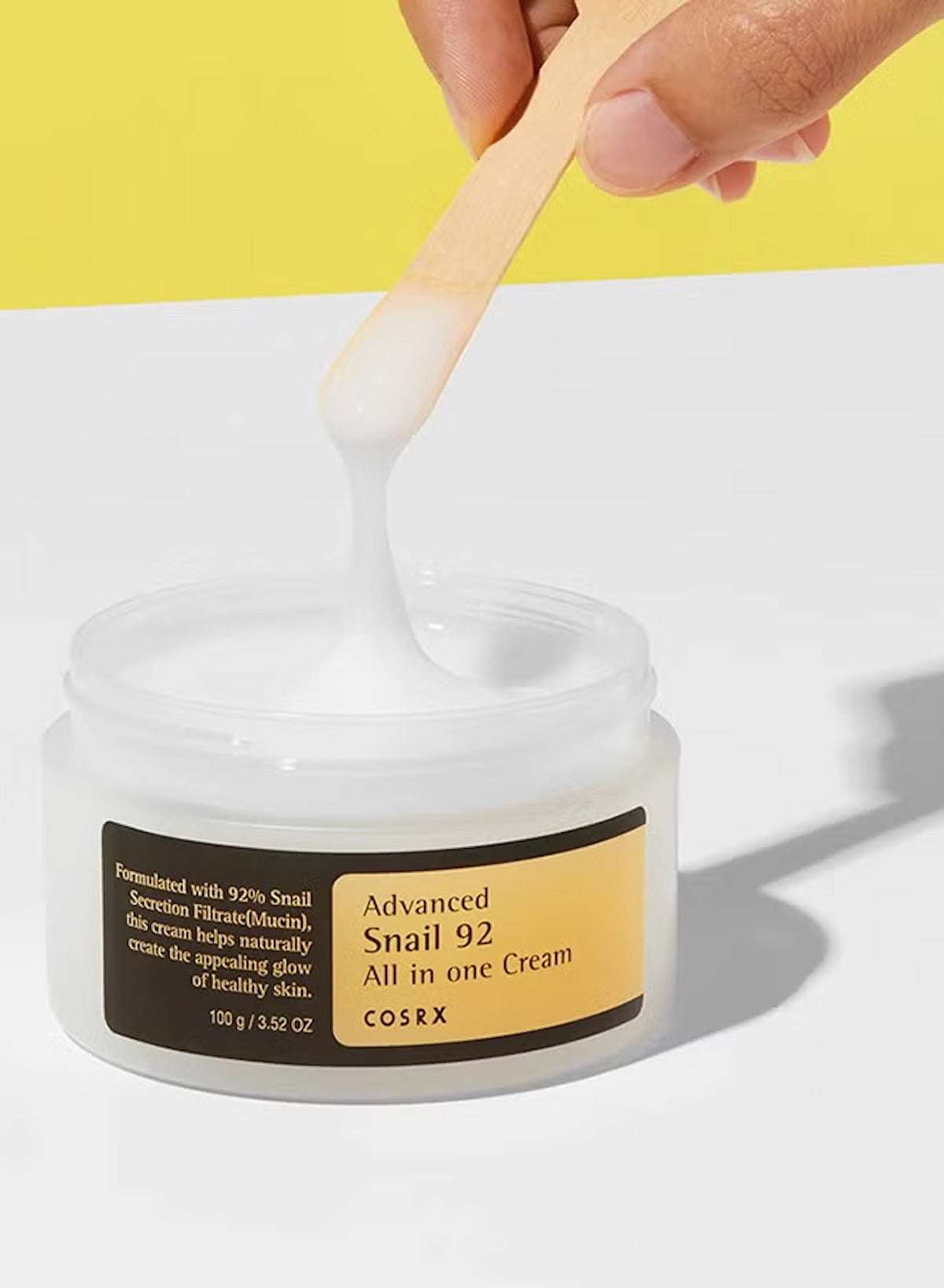 COSRX Advanced Snail 92 All In One Cream in a jar with a spatula, promoting healthy glow and hydration