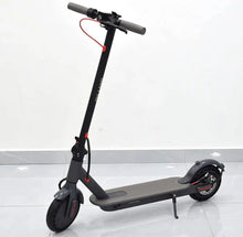Dark grey electric scooter standing with textured footplate and front wheel