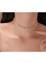 Crystal choker necklace with a gold-tone outline and small round rhinestones at the collar