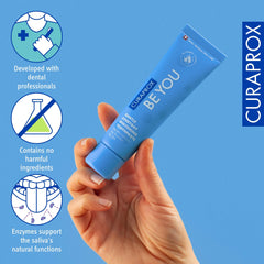 Hand holding blue Curaprox Be You gentle whitening toothpaste with dental icons for enzymes and safe ingredients