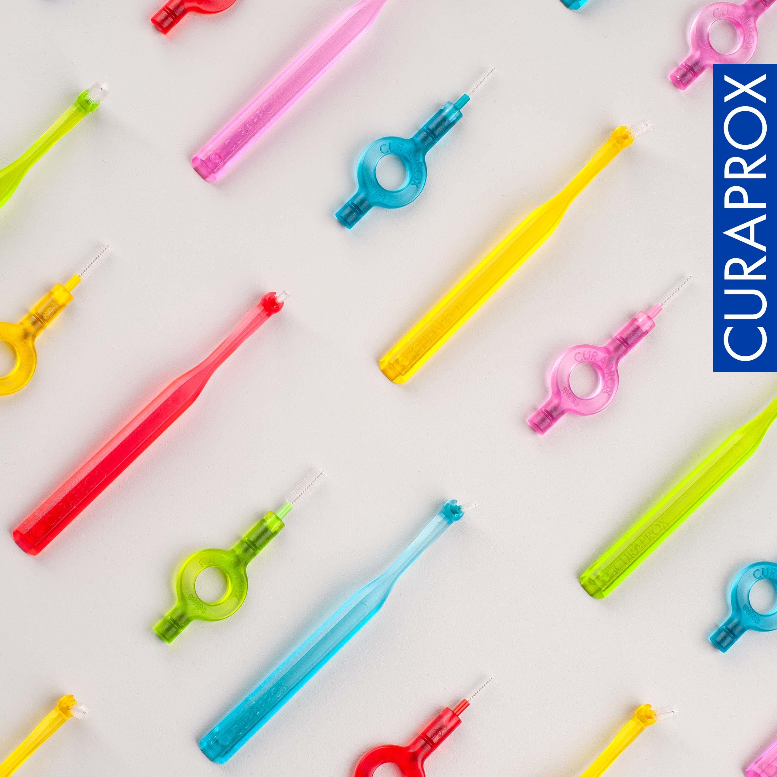 Curaprox interdental brushes starter set colorful interdental brushes with loop handles for cleaning teeth on light background