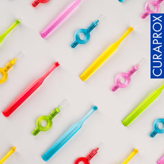 Curaprox interdental brushes starter set colorful interdental brushes with loop handles for cleaning teeth on light background