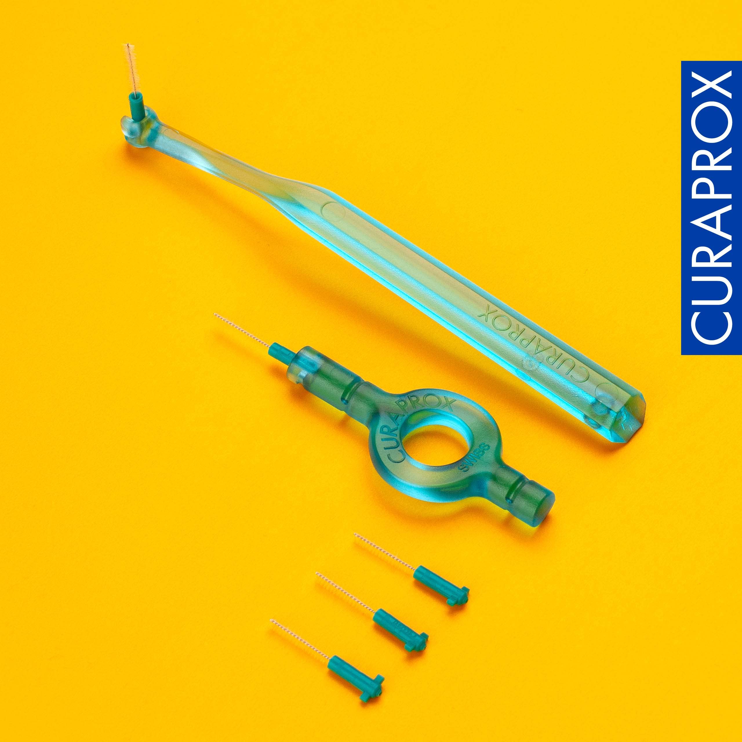Curaprox interdental brushes starter set turquoise handles and extra small brush heads on yellow background with Curaprox logo