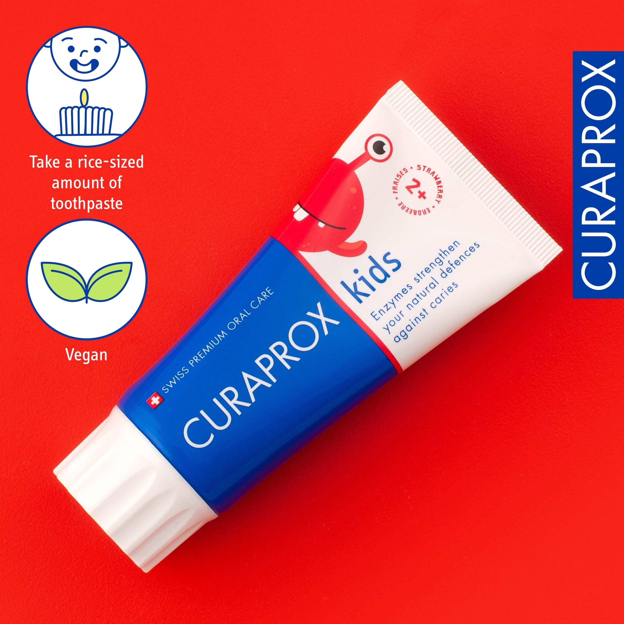 Curaprox kids fluoride toothpaste strawberry flavor tube on red background with vegan and dosing icons