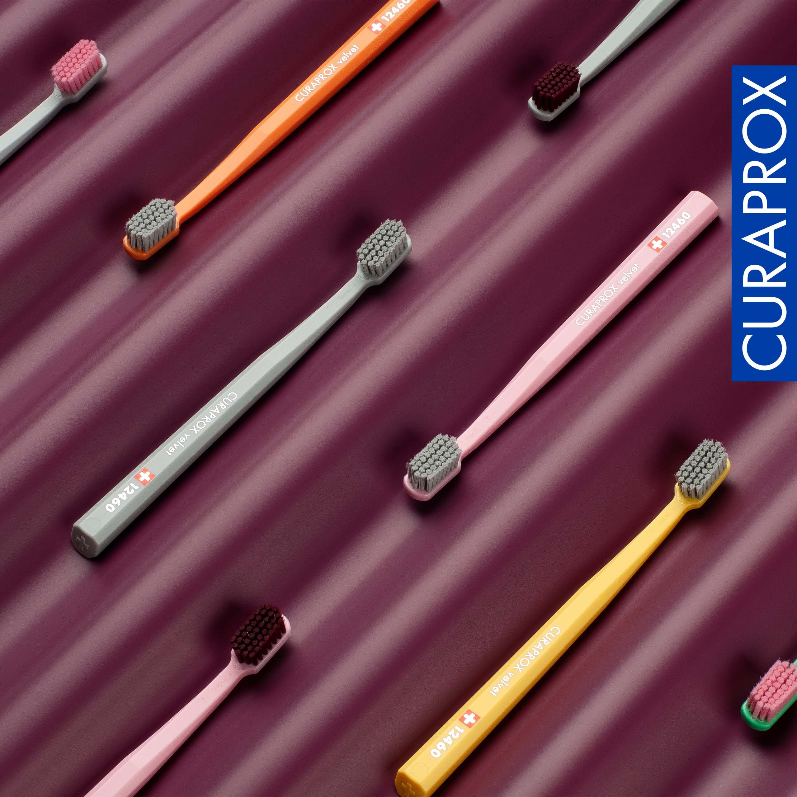 Curaprox colorful compact head toothbrushes on maroon ridged background ultra soft toothbrush for sensitive gums