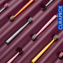 Multiple Curaprox CS 12460 toothbrushes with varied colored handles and compact bristle heads