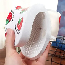 Strawberry print slide sandals close-up, textured outsole tread and white upper with red berries
