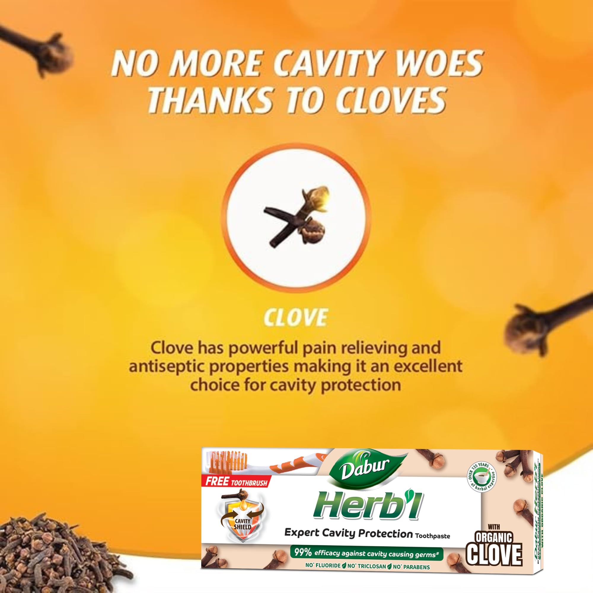 Dabur Herbal clove toothpaste for cavity protection tube with cloves image free toothbrush on orange background