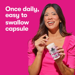 Smiling woman holding Garden of Life bottle and capsule on pink background women's probiotics for digestive health