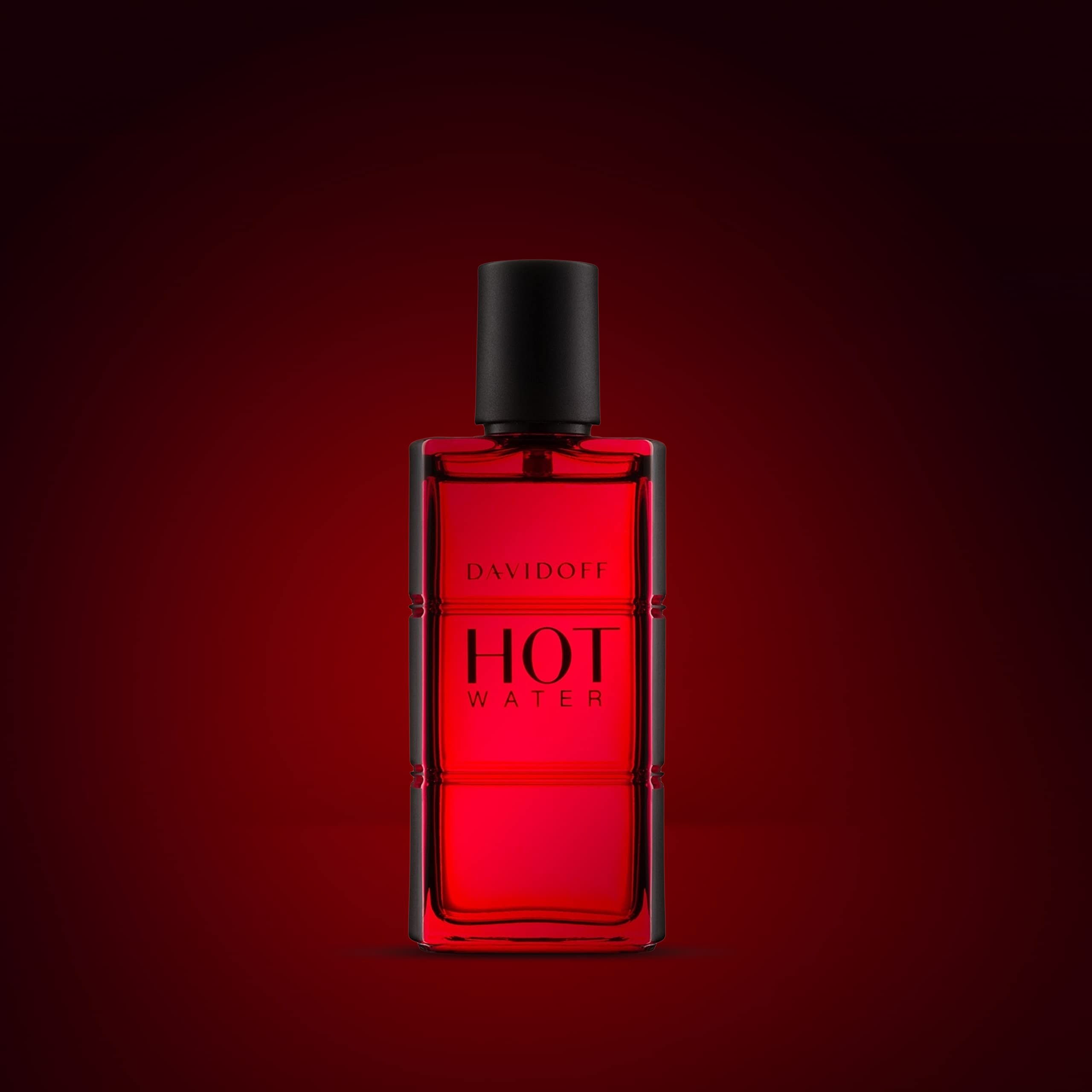 Davidoff Hot Water perfume for men in a red glass bottle with a black cap against dark background