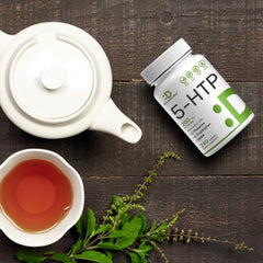 DEAL SUPPLEMENT bottle of 5-HTP supplement UAE beside tea pot cup and fresh herbs on wooden table
