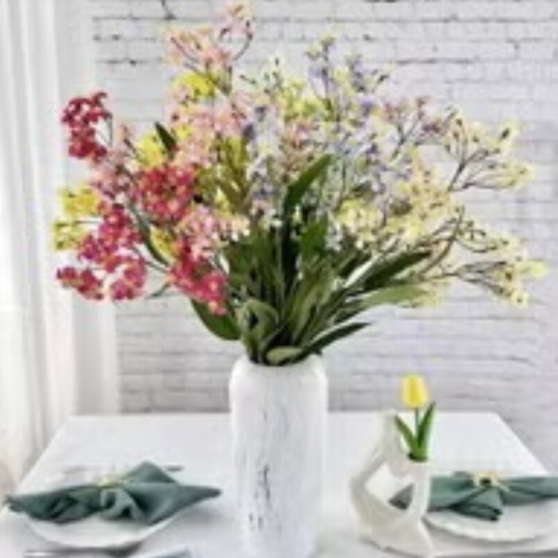 Huitich decorative fake roses for weddings in a white vase on a dining table with green napkins