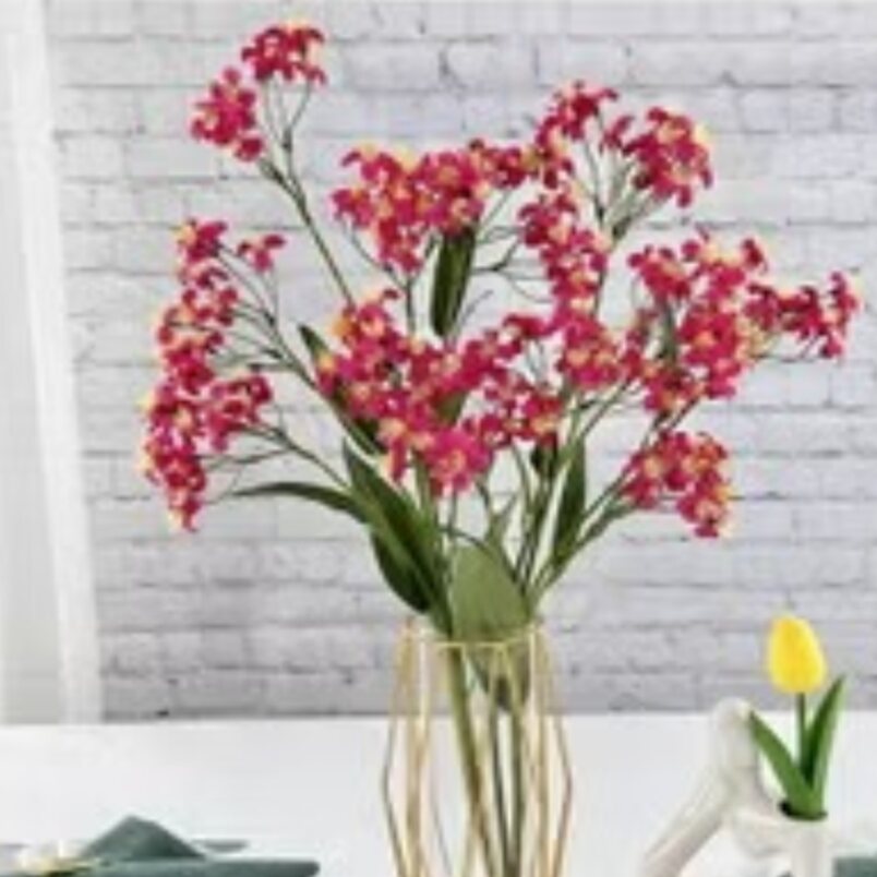 Huitich decorative fake roses for weddings in vibrant pink with green leaves in a clear glass vase