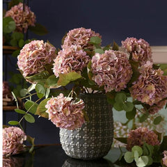 Huitich pink silk hydrangea bouquet in decorative vase with green leaves on dark surface