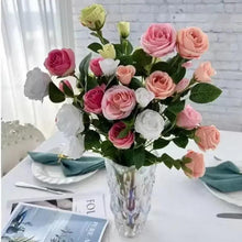Pink and peach rose bouquet with white accents and green leaves in vase