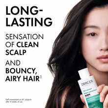 Oil correct shampoo bottle held near long dark hair on a model