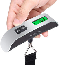 Digital luggage scale held up showing green LCD, black buttons, and metal hook