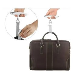 Huitich digital luggage scale with LCD display weighing a brown leather briefcase