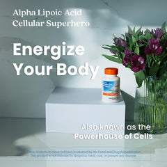 Doctors Best alpha lipoic acid 600 mg capsules bottle on white pedestal next to purple flowers energize your body